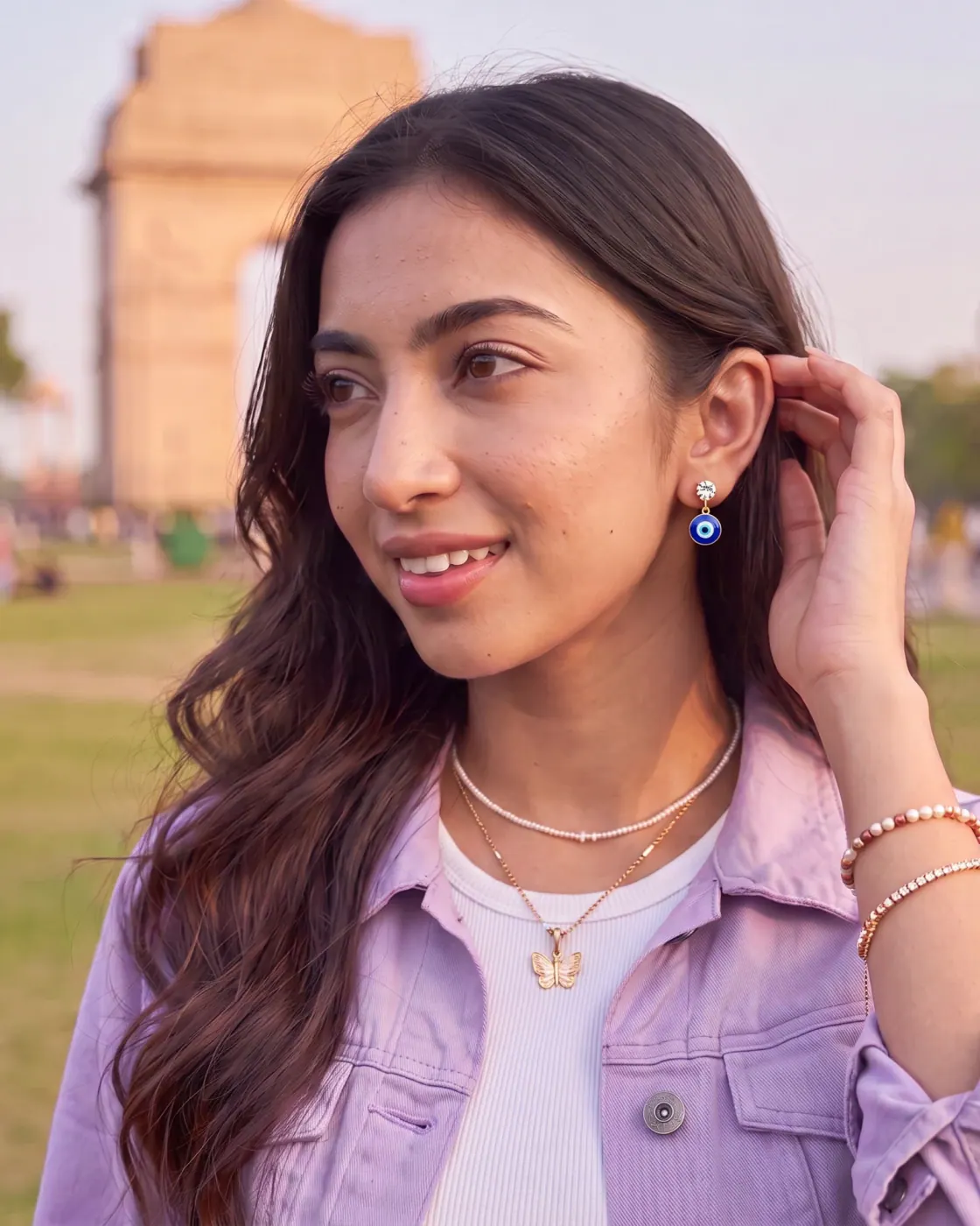 Indian woman wearing TITLI Blue Evil Eye Drop Earrings near India Gate